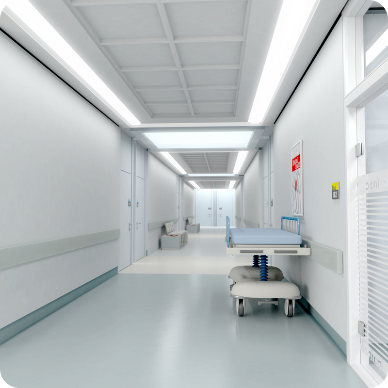Modern hospital corridor with medical equipment and patient beds.