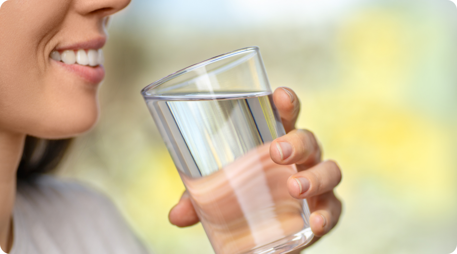 Person smiling and drinking water